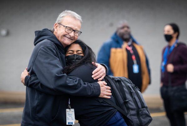 Two people smile and hug.
